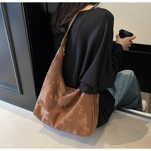 Detailed back view of a large brown vintage Hobo bag worn on the shoulder by a model