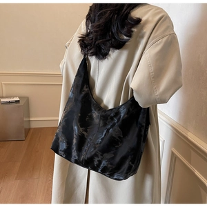 Detail of the high-gloss black marble texture on the large capacity Hobo shoulder bag