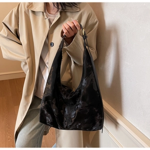 Detail of black Hobo tote bag showing marble texture and adjustable shoulder strap