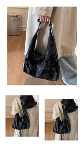 Detail view of large black hobo bag with marble texture and adjustable gold buckle strap