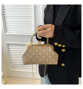 Detailed view of beige vintage shell bag with gold carved metal handle and chain strap