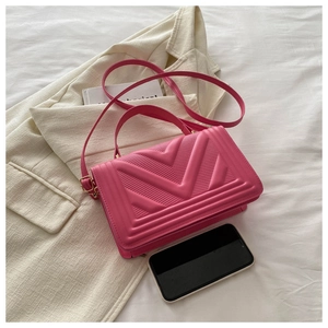 Detail view of pink PU leather square bag with V-shaped quilting and crossbody strap