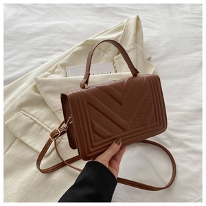 Close-up of brown PU leather bag with detailed V-shaped quilting and gold hardware