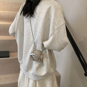 Mini fish-shaped silver metal crossbody bag with scale texture and thin chain on model