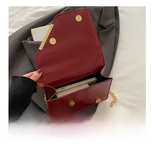 Interior view showing capacity of dark red leather chain bag with gold magnetic buckle