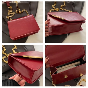 Detail shot of a dark red chain crossbody bag showing interior capacity and leather texture