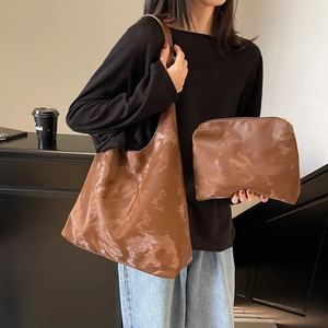 Borsa tote in pelle marrone con pochette coordinata indossata per uno stile minimalista