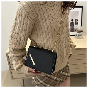 Close-up of black PU leather crossbody bag with gold metal trim and chain strap details