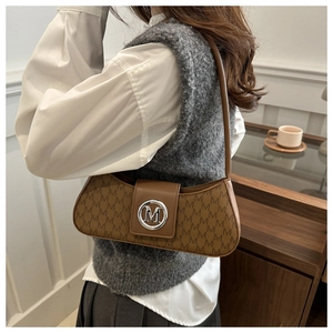 Detail of coffee brown shoulder bag featuring M-pattern print and silver metallic buckle