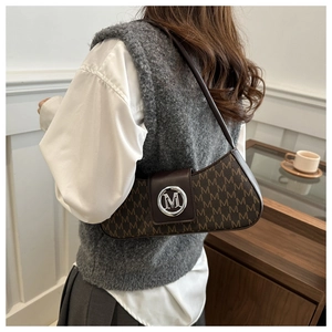 Detailed close-up of brown monogram hobo bag with vintage metal M buckle on shoulder