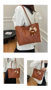 Détail du sac cabas marron vintage avec porte-clés peluche et texture en similicuir usé