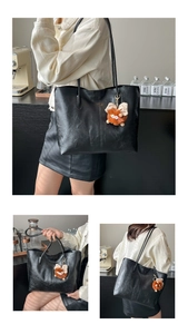 Détail du sac cabas en similicuir noir avec un joli pendentif monstre en peluche marron