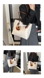 Détail du sac fourre-tout blanc cassé avec anses brunes et breloque peluche monstre