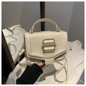 Detail of a beige vintage square bag with a gold buckle and adjustable strap
