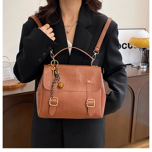 Detailed view of vintage brown PU leather backpack with metallic buckle and embossed logo