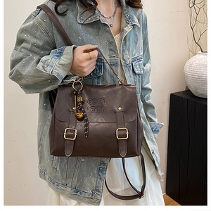 Close-up of retro brown backpack with buckle straps and textured synthetic leather detail