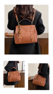 Detailed macro view of the COIN embossed logo and vintage buckle on brown faux leather bag