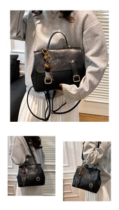 Close-up of black retro PU leather handbag featuring vintage gold buckles and COIN embossing