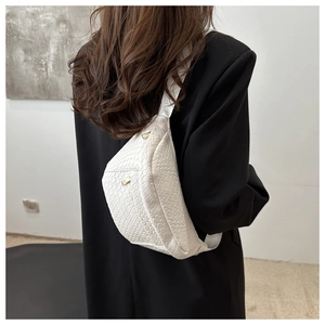 Detail of white woven PU leather texture and silver metal zipper on half-moon chest bag