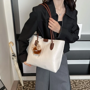 Grand sac fourre-tout blanc vintage avec anses marrons et charm sur un mannequin