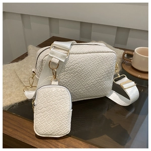 Detail of white woven texture crossbody bag with detachable coin purse and gold hardware