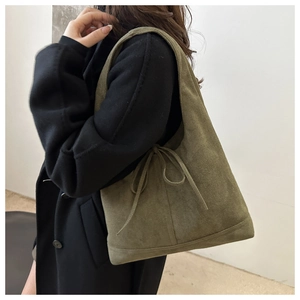 Detail of olive green suede tote bag showing side bow tie and drawstring texture