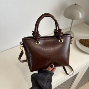Détail du sac à main en cuir marron avec garnitures dorées et gaufrage de texte mode