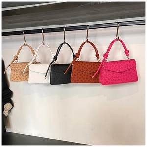 Detailed row of floral embossed handbags in five colors hanging on metal S-hooks