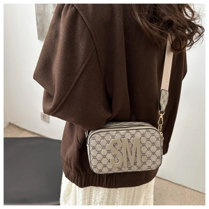 Detailed look at the vintage monogram crossbody bag with wide canvas strap on model