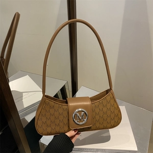 Close-up of brown monogram underarm bag with circular silver metal M logo buckle