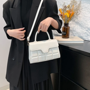 White chocolate-patterned shoulder bag with handle for women in a stylish setting