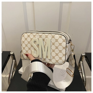 Detail of square crossbody bag with brown monogram print, SM logo and wide fabric strap