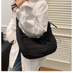 Modelo con bolso acolchado negro de gran capacidad con cordón ajustable y estilo moderno