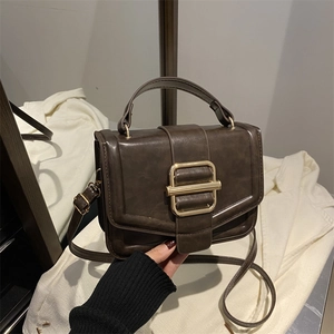 Détail du sac à main rétro marron avec boucle dorée et bandoulière réglable