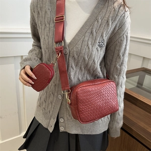 Deep red woven crossbody camera bag with adjustable wide strap and mini round coin purse
