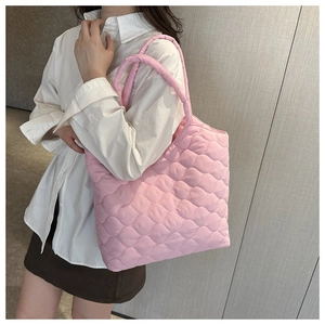 Pink quilted nylon tote bag with wave pattern stitching shown styled on a model