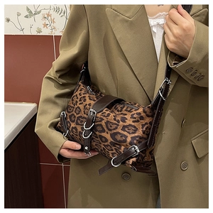 Détail du sac bandoulière léopard avec lanières en cuir marron et boucles en métal argent