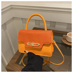Detail view of the orange woven texture lid and golden metal buckle on crossbody bag