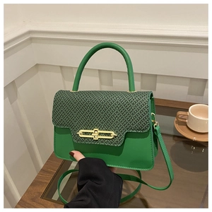 Close-up of green vintage handbag with woven texture flap and golden metal clasp