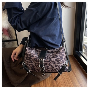 Détails macro d'un sac bandoulière léopard avec boucles décoratives en cuir noir