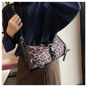 Détail du sac bandoulière à motif léopard avec boucles argentées sur un mannequin