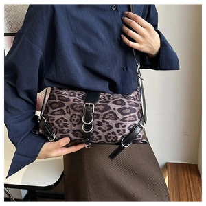 Vue détaillée du sac à bandoulière léopard avec bordures en cuir et boucles métalliques