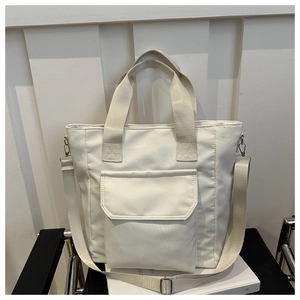 Detail of water-resistant nylon tote bag featuring front pocket and adjustable strap
