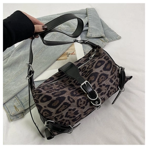 Détail d'un sac à main léopard avec boucles métalliques et lanières en cuir noir