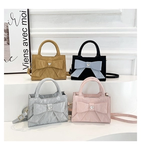 Detail view of bow-knot handbags in khaki, blue, silver, and pink with rhinestone hearts