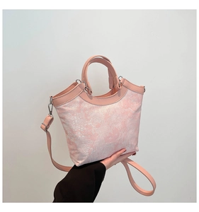 Dettaglio ravvicinato della borsa tote rosa in tessuto con ricami floreali bianchi