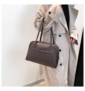 Detail of a large dark brown PU leather tote bag with a minimalist front pocket