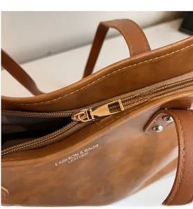 Detail of smooth gold zipper and premium leather texture on brown tote bag