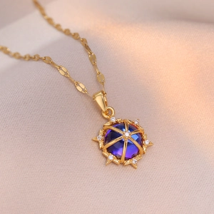 Gold-plated necklace featuring a blue gradient floral pendant on champagne silk fabric