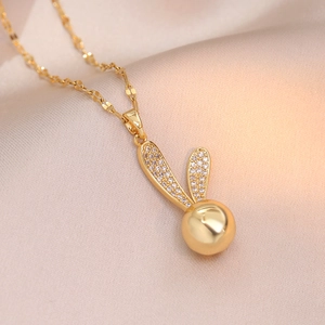Collier oreilles de lapin doré avec zircons cubiques sur fond de soie champagne